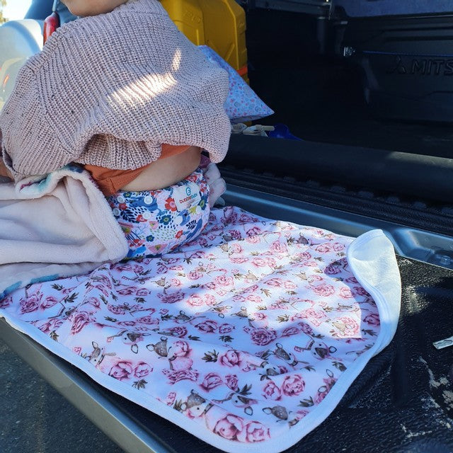 baby on a change mat in the back of the car. change the nappy anywhere with a bubblebubs change mat