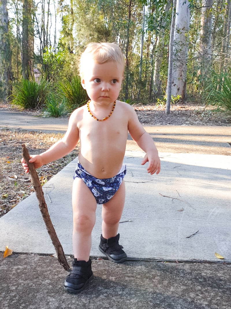 Confident toddler waling a path with his stick, boots and Bubblebubs Candie cloth nappy. Nothing is going to stop him from having a good time